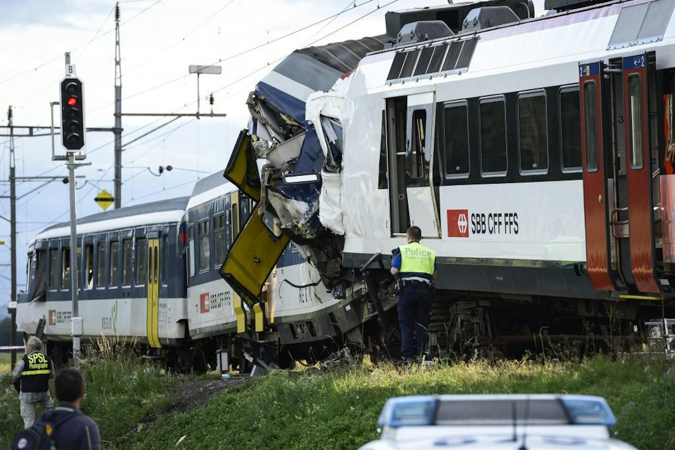Police inspect the site where two passenger trains collided head-on in Granges-pres-Marnand, western Switzerland, Monday, July 29, 2013. Numerous people have been injured.