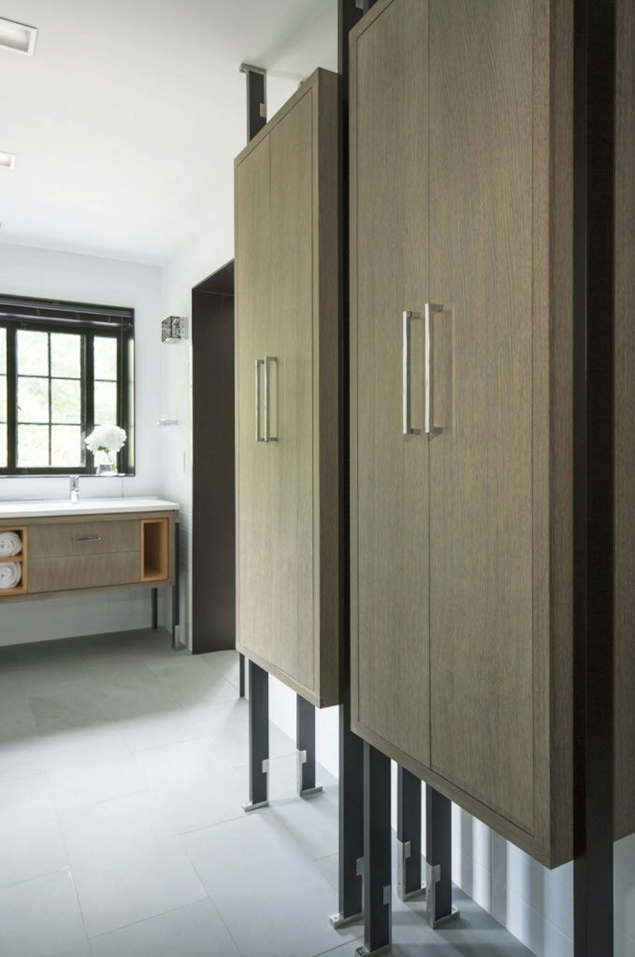 The bathroom's cabinets are raised off the floor on black lacquered legs