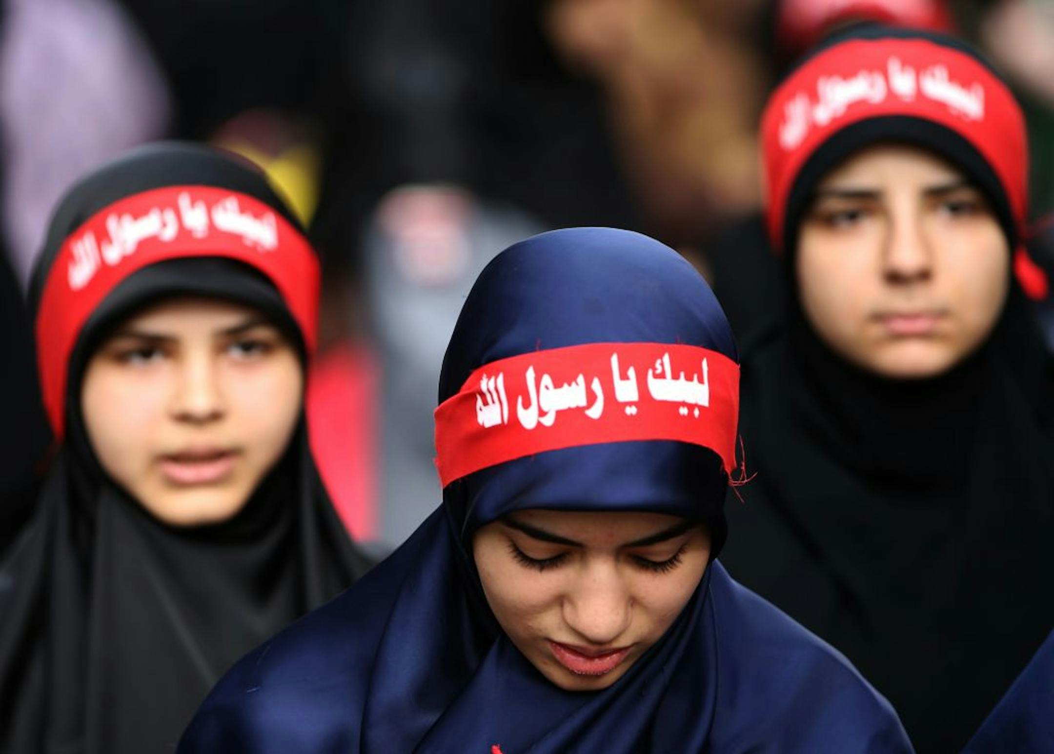 In this picture taken on Monday Sept. 17, 2012, Hezbollah veiled women wear Arabic headbands that read, "at your service God's prophet," during a rally denouncing an anti-Islam film that has provoked unrest in Muslim countries worldwide.