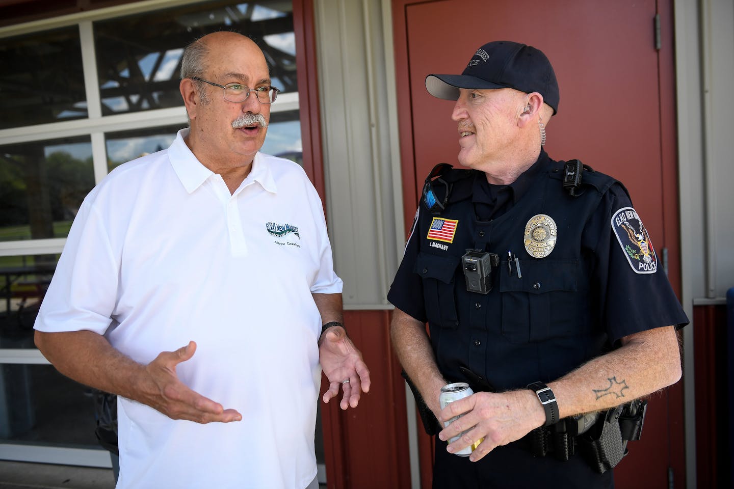 Elko New Market Mayor Bob Crawford talked with officer John Machaby with the Elko New Market Police during the city's 10-year anniversary celebration of their merger in mid August. ] AARON LAVINSKY &#xef; aaron.lavinsky@startribune.com It's been 10 years since Elko and New Market merged into the small affluent suburb of Elko New Market, yet residents seem to be having a hard time accepting that fact. The town of 4,500 is divided by separate zip codes, children attend separate school districts, a