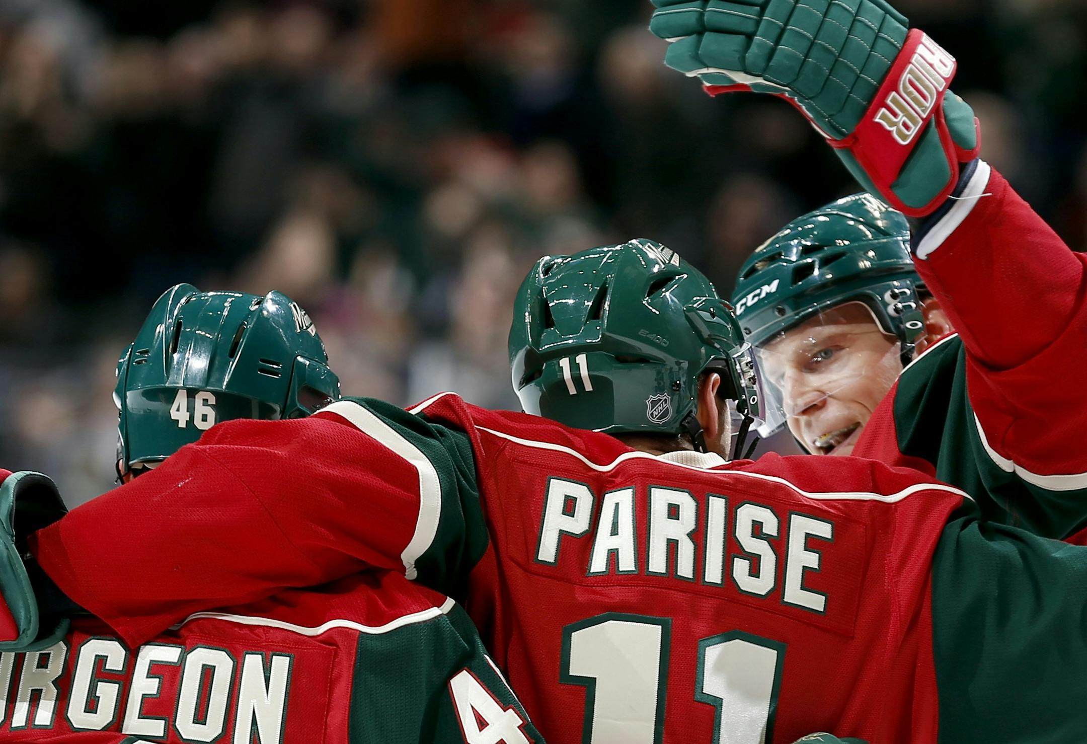 Jared Spurgeon, left, Zach Parise (11), and Mikko Koivu celebrate a goal by Parise in the first period against Vancouver.