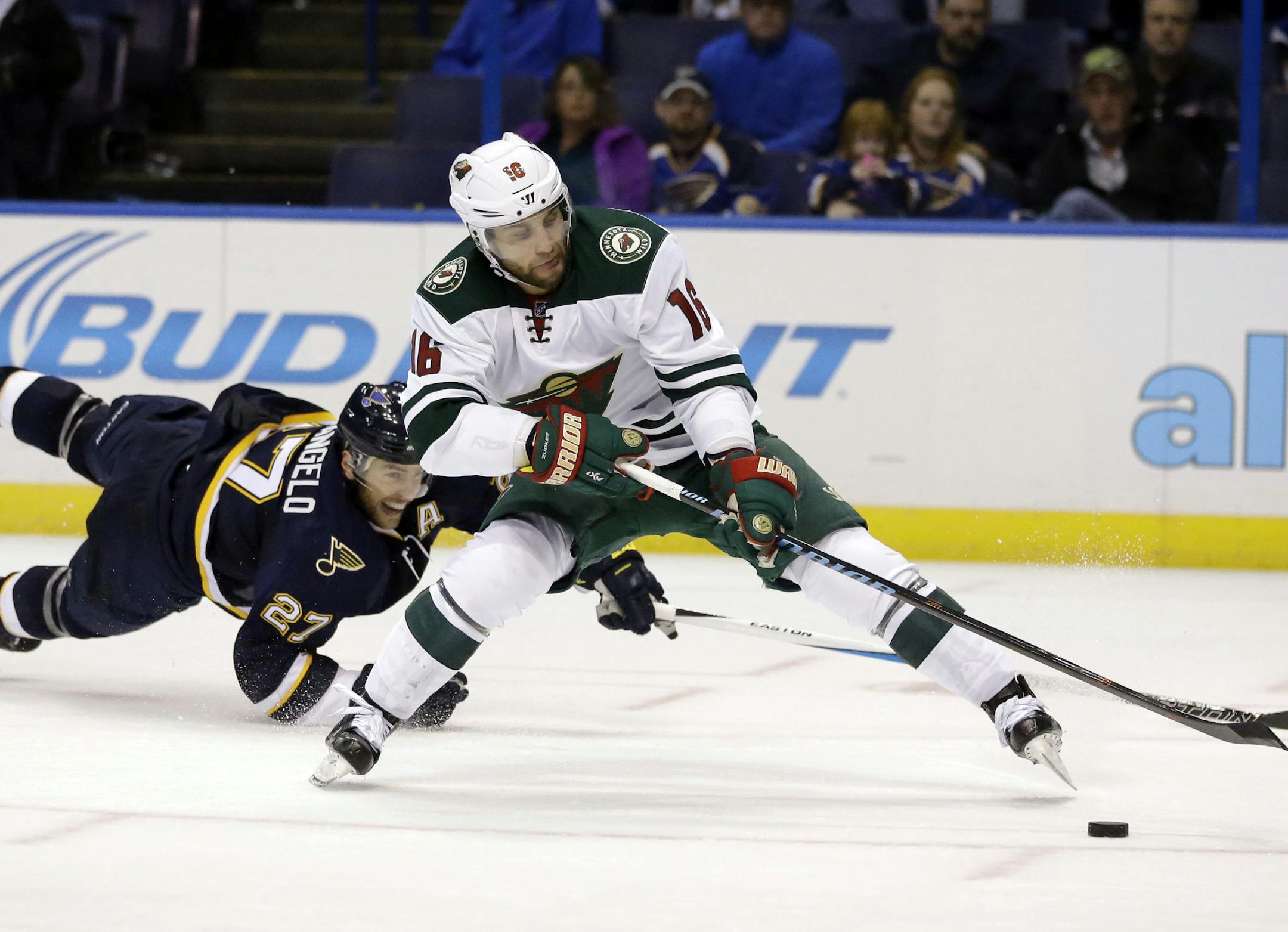 Minnesota Wild's Jason Zucker, right, reaches for a puck alongside St. Louis Blues' Alex Pietrangelo.