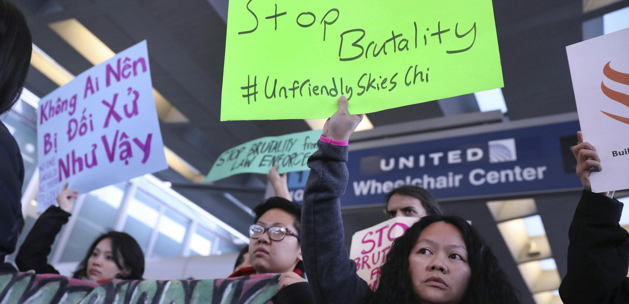 People with Asian community organizations from Chicago hold signs to protest after Sunday's confrontation where David Dao, 69, of Elizabethtown, Ky., was removed from a United Airlines airplane by Chicago airport police at O'Hare International Airport, during rally near United's counter at the airport's Terminal 1 in Chicago on Tuesday, April 11, 2017. (Chris Sweda/Chicago Tribune via AP)