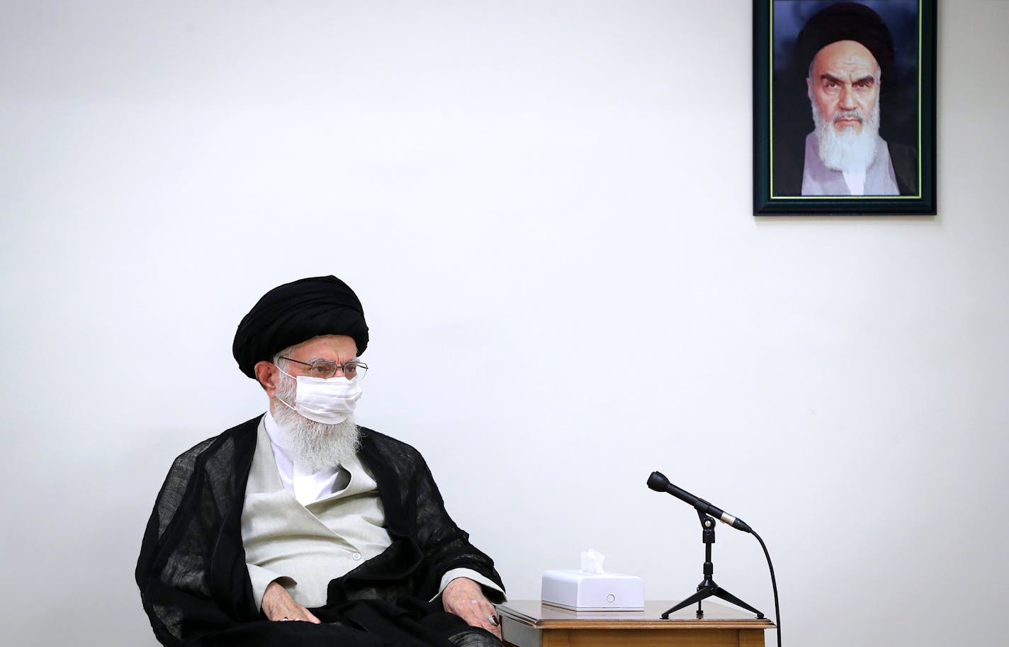 In this picture released by an official website of the office of the Iranian supreme leader on June 31, 2020, Supreme Leader Ayatollah Ali Khamenei wears a protective face mask to help prevent to spread of the coronavirus while sitting under a portrait of the late revolutionary founder Ayatollah Khomeini during a meeting in Tehran, Iran. Iran on Sunday instituted mandatory mask-wearing as fears mount over newly spiking reported deaths from the coronavirus, even as its public increasingly shrugs