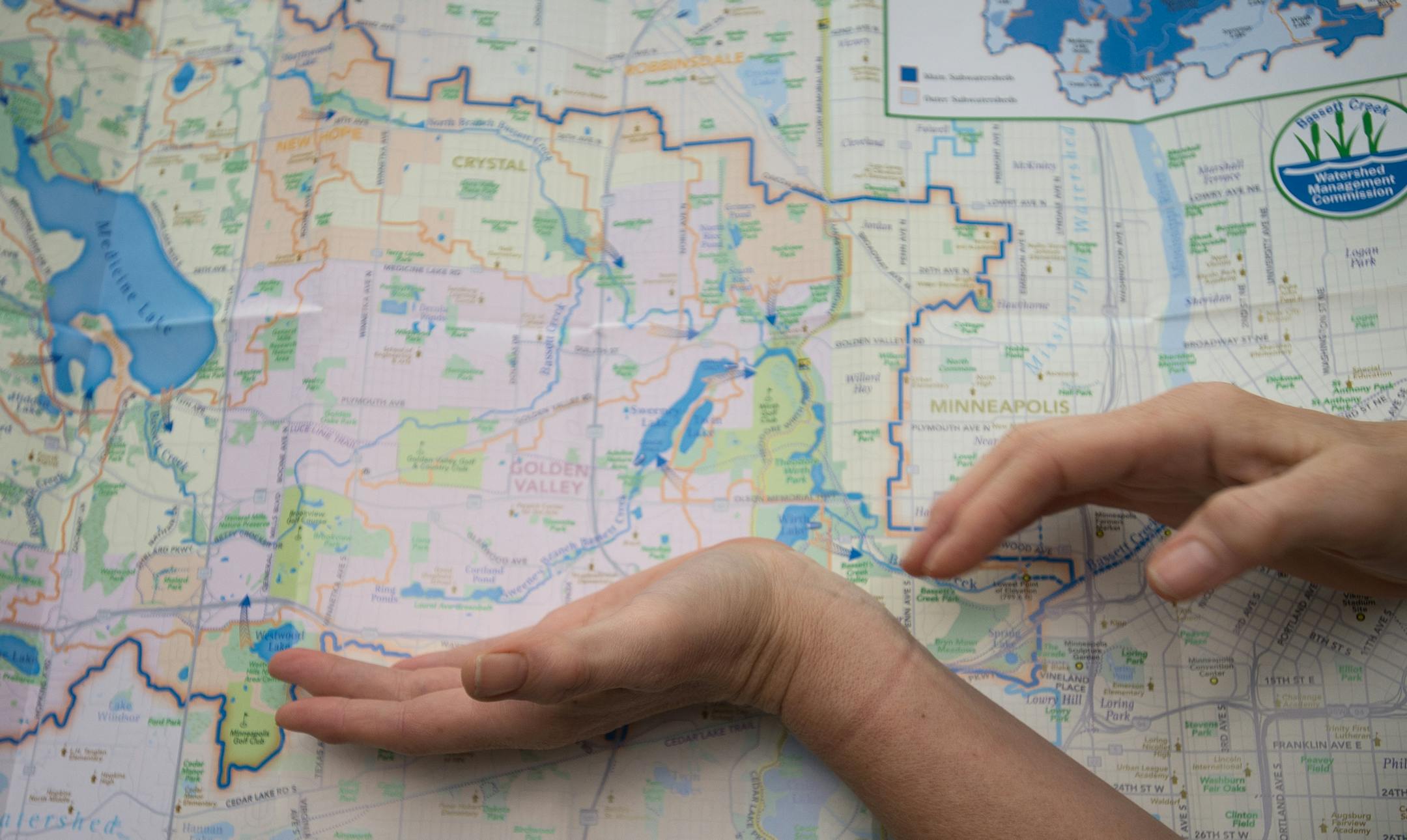 Golden Valley resident Jane McDonald Black (CQ) shows the flow of creeks that feed into Sweeney Lake on a map of the Bassett Creek Watershed in her home Wednesday afternoon. ] AARON LAVINSKY • aaron.lavinsky@startribune.com Golden Valley residents are working to save Sweeney Lake from degradation caused by nearby development. The lake was crystal clear before the construction of the I-394 and widening of Olson Memorial Highway caused salt and sediment to flow into the lake. Local activist
