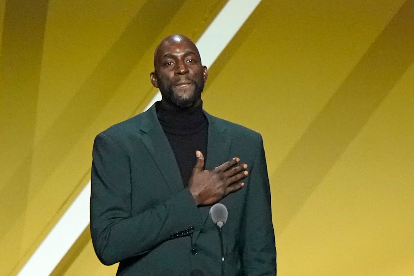 Kevin Garnett puts his hand on his heart during a speech during the 2020 Basketball Hall of Fame enshrinement ceremony, Saturday, May 15, 2021, in Uncasville, Conn. (AP Photo/Kathy Willens)