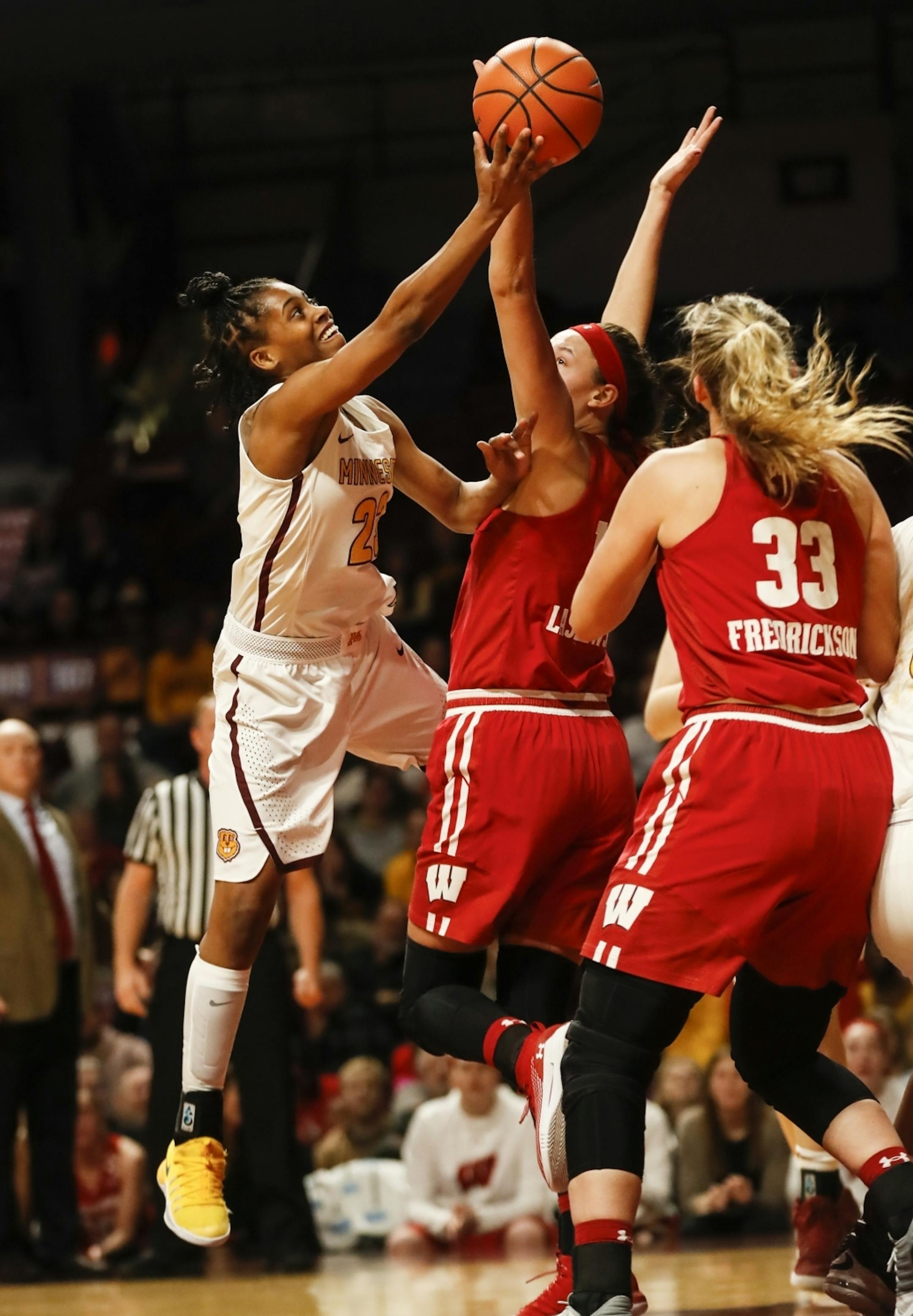 Minnesota Golden Gophers guard Kenisha Bell (23) went for a shot against Wisconsin Badgers forward Abby Laszewski (14) in the first half.