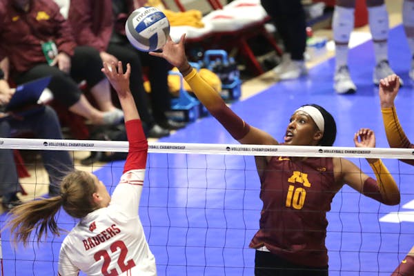 Minnesota's Stephanie Samedy (10) tips the ball over the net against Wisconsin's Julia Orzol (22) during an NCAA regional final in Madison, Wis., Satu