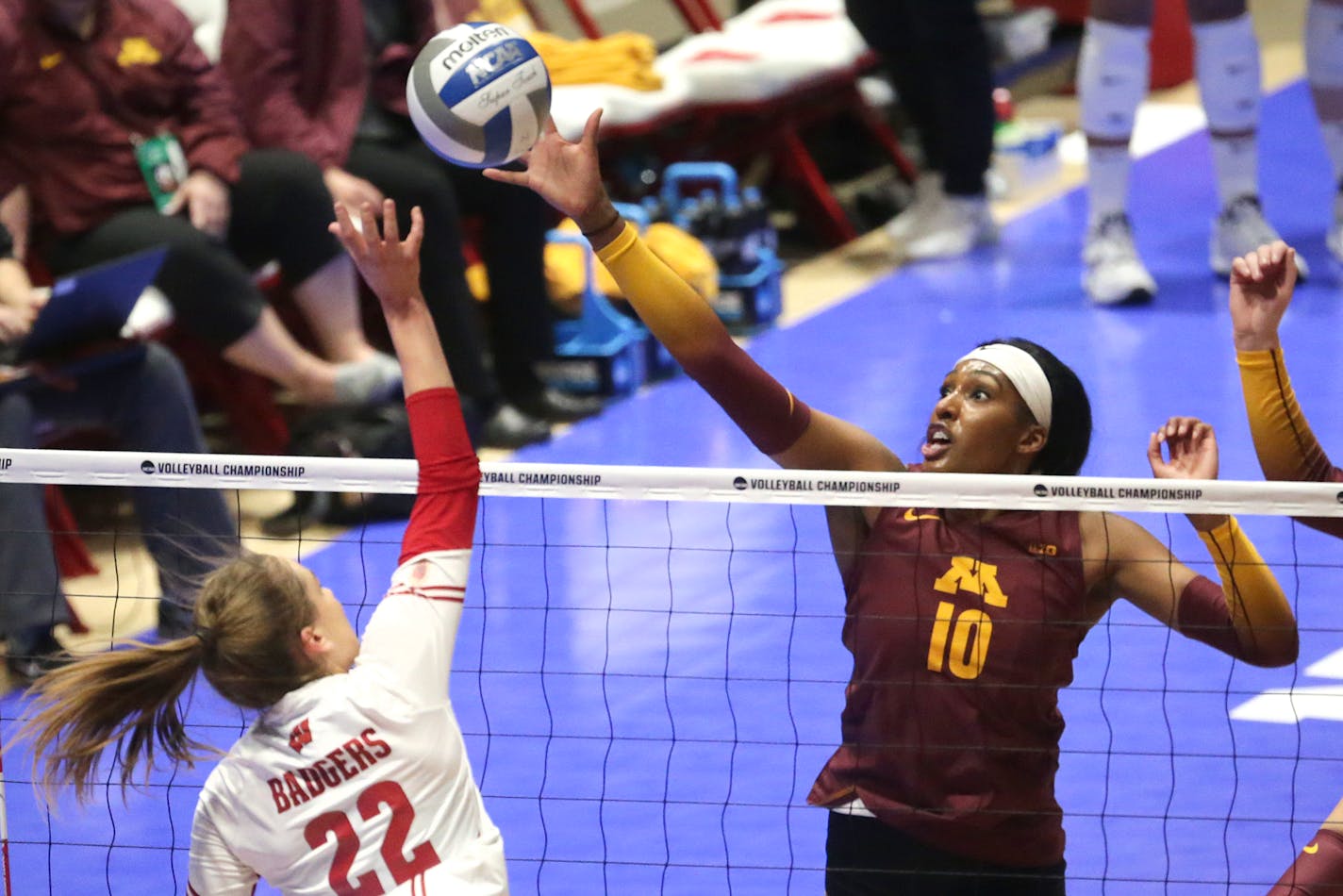 Minnesota's Stephanie Samedy (10) tips the ball over the net against Wisconsin's Julia Orzol (22) during an NCAA regional final in Madison, Wis., Saturday, Dec. 11, 2021. KAYLA WOLF, STATE JOURNAL