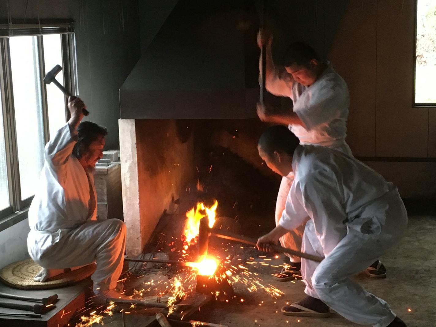 "The process is the art": In a timeless tradition, Kanefusa Fujiwara, a 25th-generation swordsmith, directs two sledgehammering apprentices as he forges a sword in Seki City, Japan.