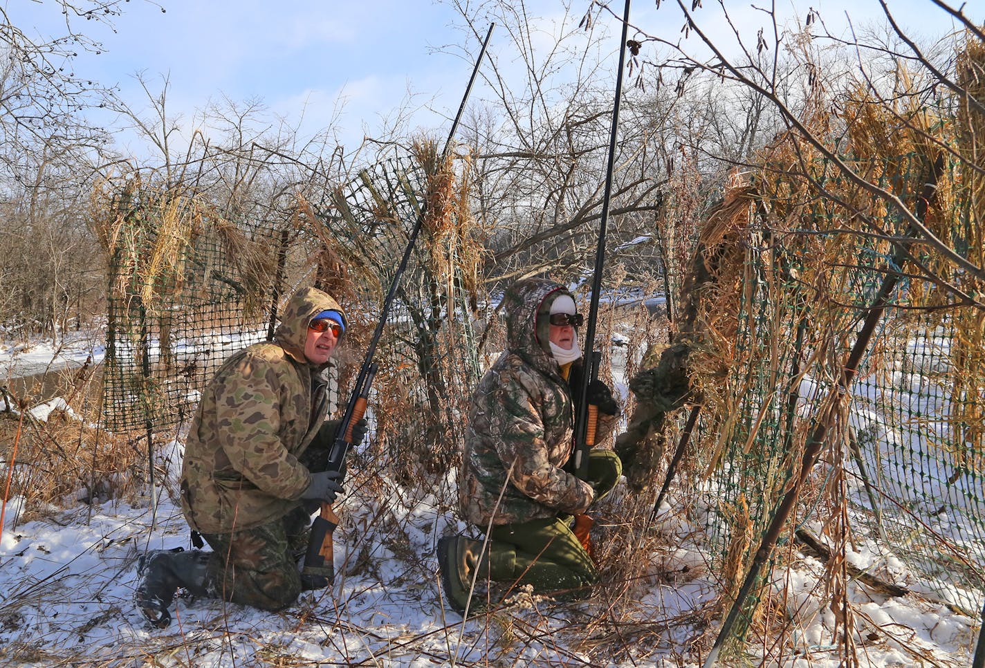 Wendell Diller and his wife, Galina, armed with shotguns with 7-foot-long barrels, look for geese approaching their decoys in partially frozen river backwaters.