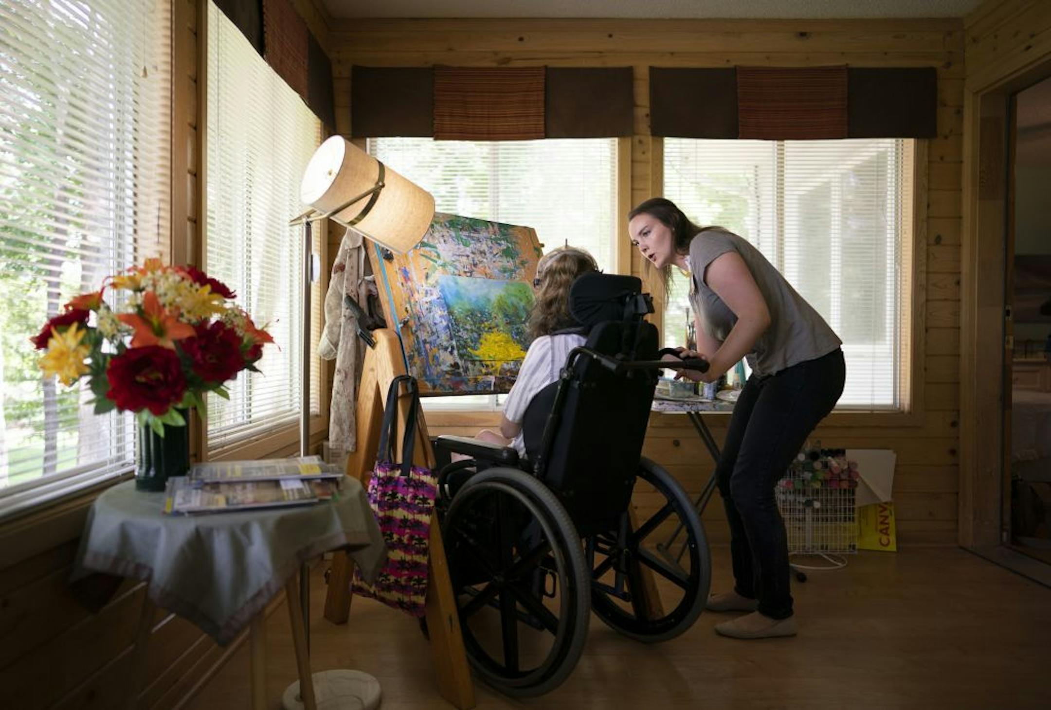 Kari Wagner worked on a painting while her palate was held by Carrie Ingish, a therapeutic recreation specialist with Gillette Children's Specialty Healthcare.
