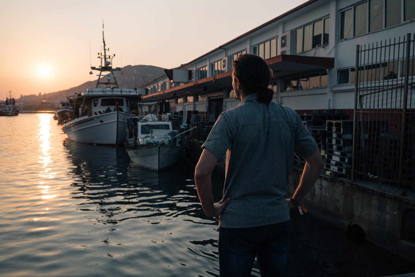 Lefteris Arapakis watches the sun set over the horizon on July 25. MUST CREDIT: Photo by Alice Martins for The Washington Post.