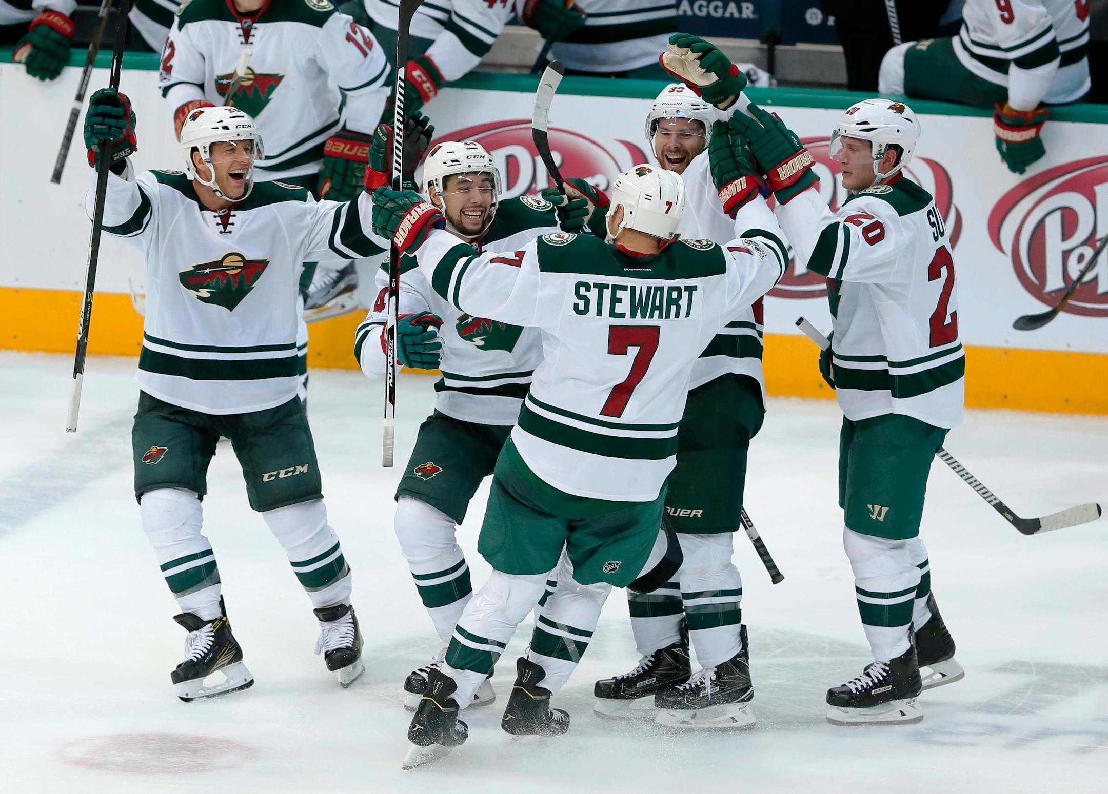 Minnesota Wild right wing Chris Stewart (7) celebrates his shootout goal with Jason Pominville, from left, Matt Dumba, Nate Prosser (39) and Ryan Suter (20) in their 3-2 Wild win over the Dallas Stars in an NHL hockey game in Dallas, Tuesday Jan. 24, 2017. (AP Photo/Tony Gutierrez)