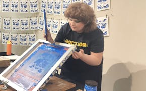 Lynaea Russom, a 2024 graduate of the Minneapolis College of Art and Design (MCAD), screenprints an original print at an auction.