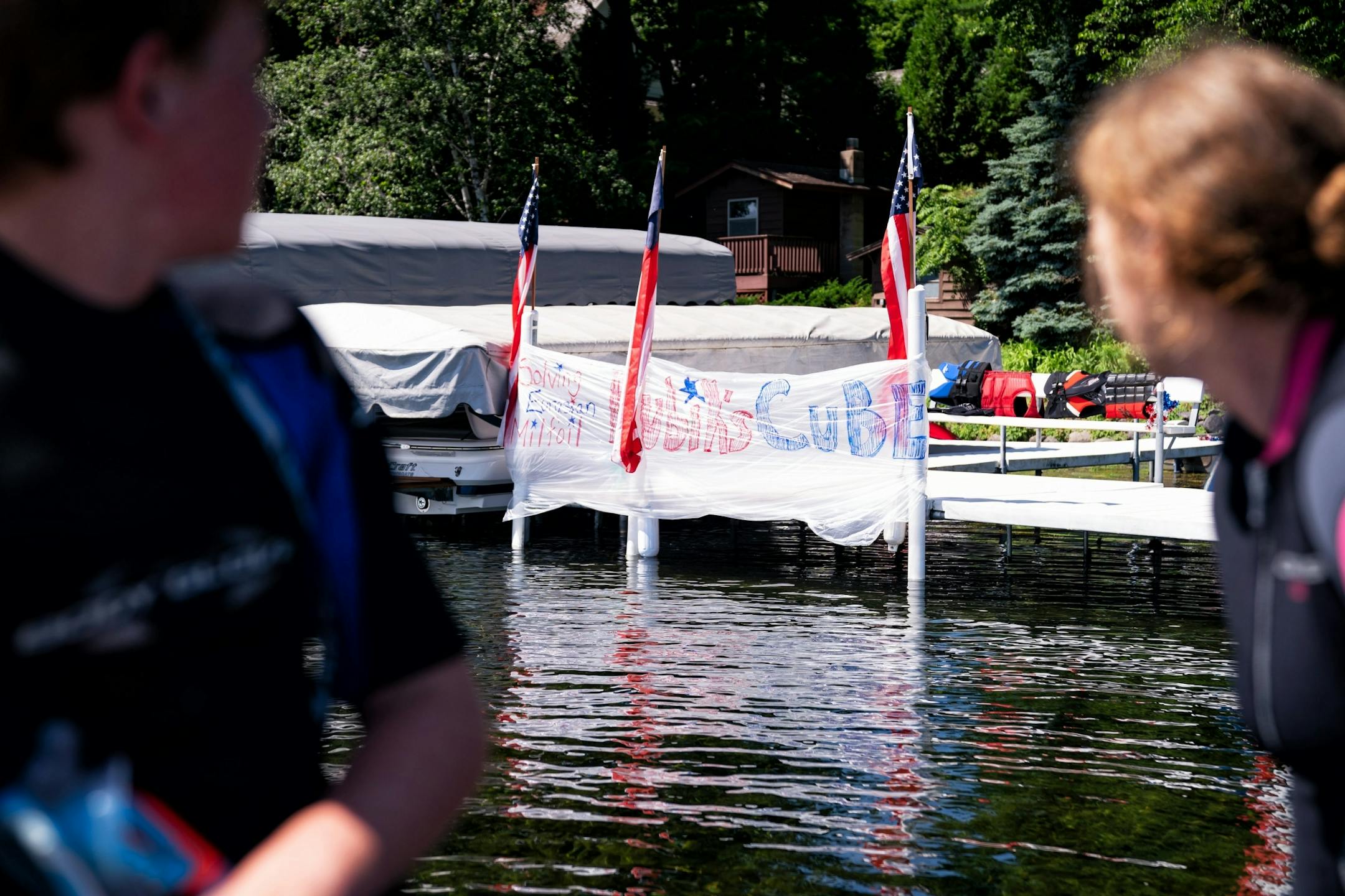 A banner from the 1980's themed Fourth of July parade reads "Solving Eurasian Milfoil Rubik's Cube".