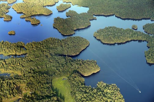 A boat navigates the waters of Namakan Lake near Kettle Falls in Voyageurs National Park.