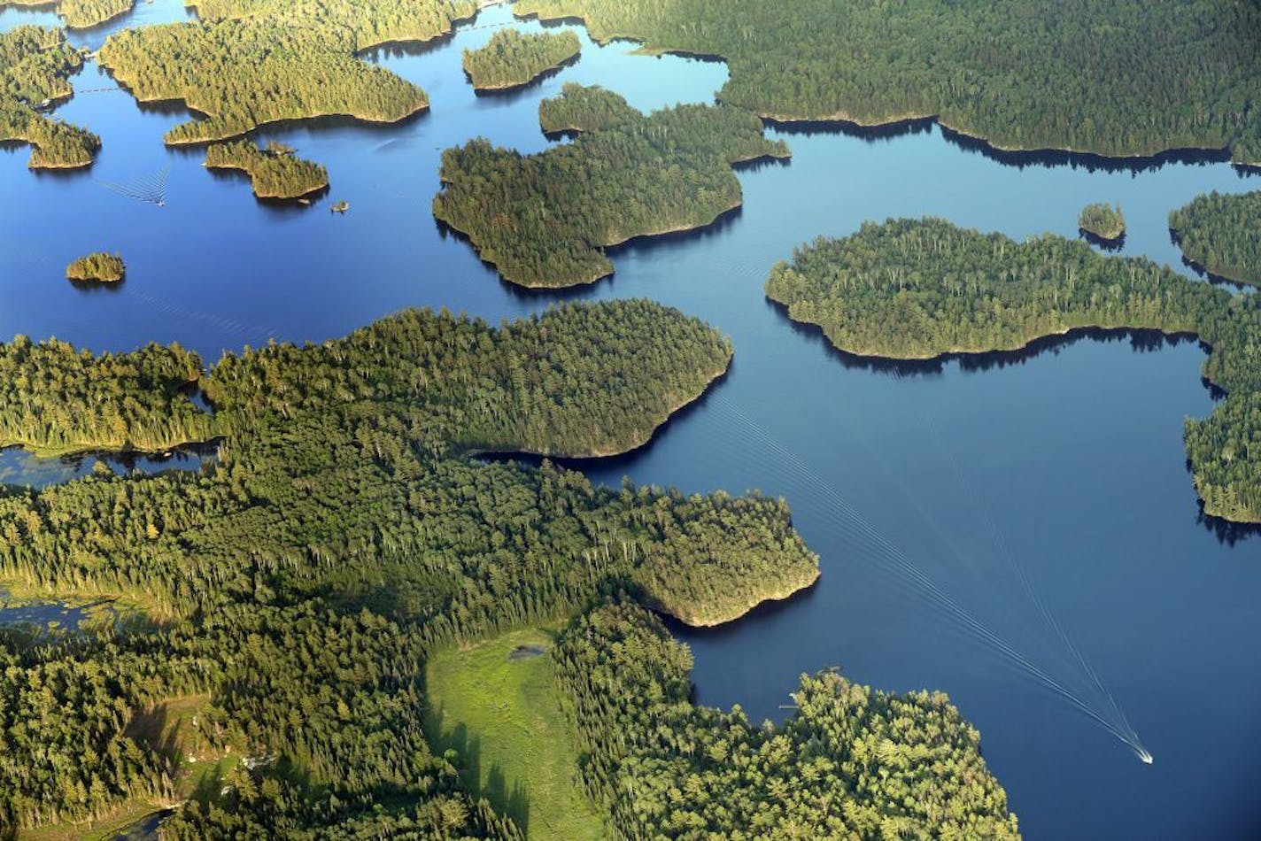 A boat navigates the waters of Namakan Lake near Kettle Falls in Voyageurs National Park.