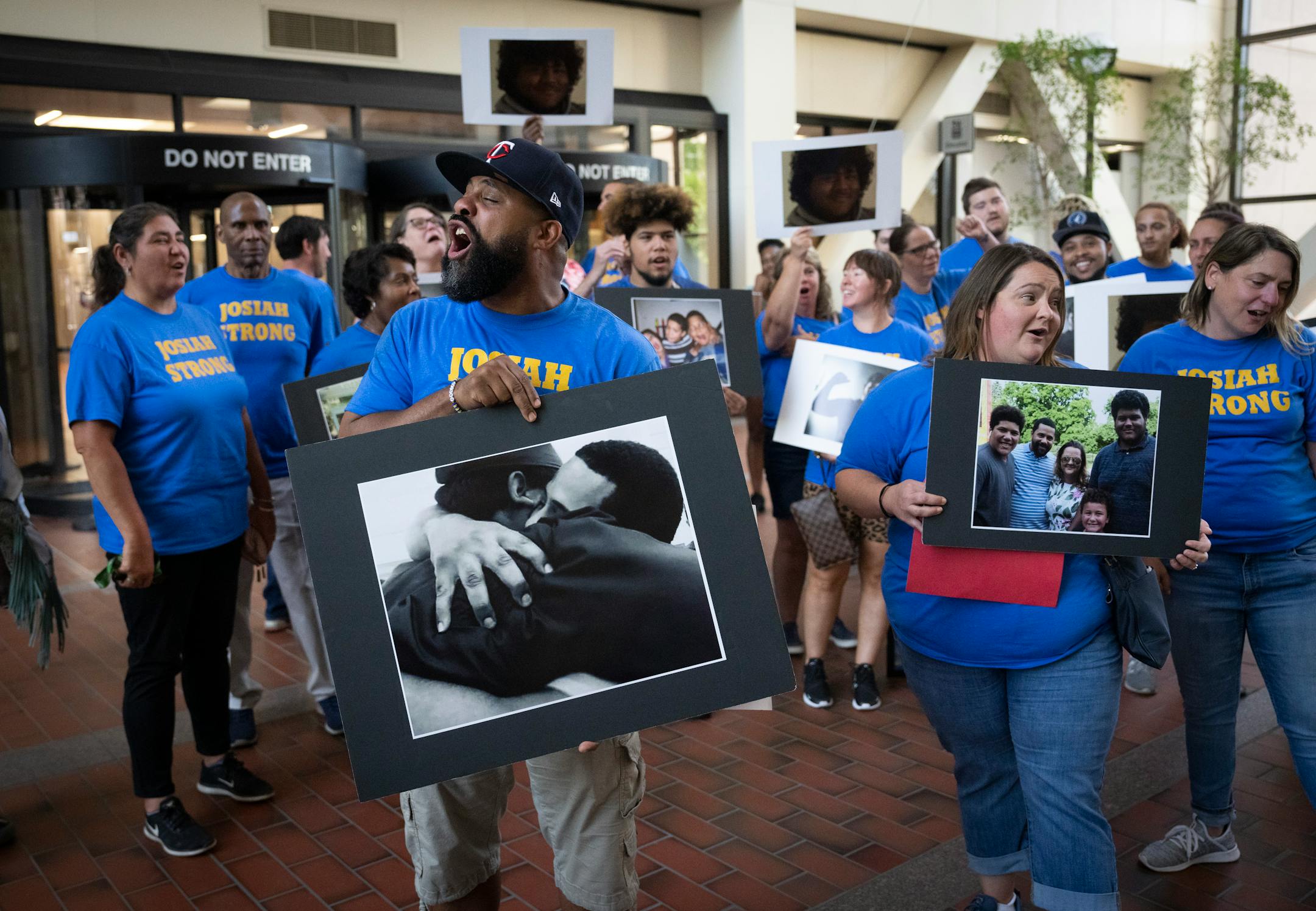 Josiah Oakley's father Clifton Johnson shouts "Josiah Strong" as family and friends hold photos of Oakley after the sentencing for Sylvester Vaughn.