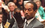 In this June 21, 1995 file photo, O.J. Simpson holds up his hands before the jury after putting on a pair of gloves similar to the infamous bloody glo
