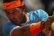 FILE - In this May 8, 2019, file photo, Rafael Nadal, from Spain, returns the ball to Felix Auger-Aliassime, from Canada, during the Madrid Open tenni