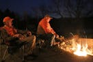 On the eve of the firearms der opener, Terry Arnesen, left, and John Weyrauch cook venison backstrap over an open fire from a whitetail taken last sea