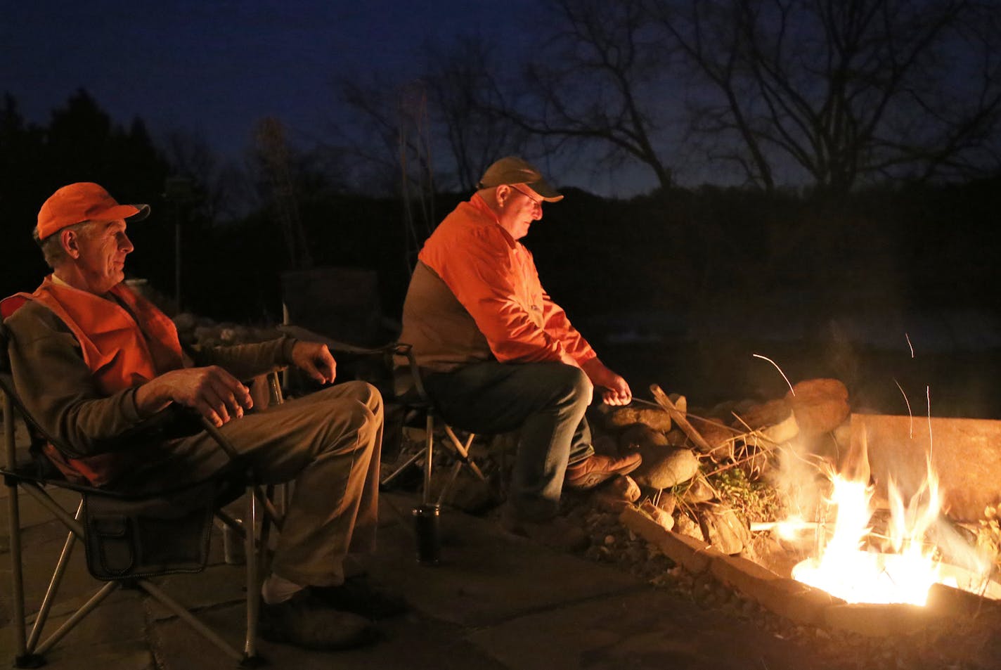 On the eve of the firearms der opener, Terry Arnesen, left, and John Weyrauch cook venison backstrap over an open fire from a whitetail taken last season. Likw many Minnesota deer hunters, particularly during this season when the pandemic is on everyone's mind, the two are forsaking traditional "up north'' hunts in favor of staying close to home and hunting in the metro's outer ring.