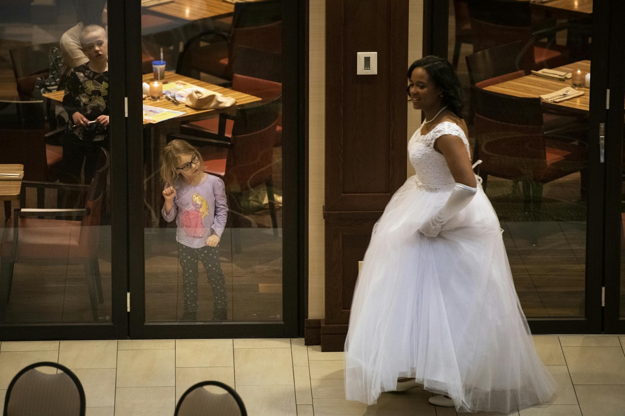 Teagan Burr, 4, of East Bethel, looked in awe as Morgan Phillips, a senior at The Blake School, walked through the Marriott Hotel Saturday before her cotillion.