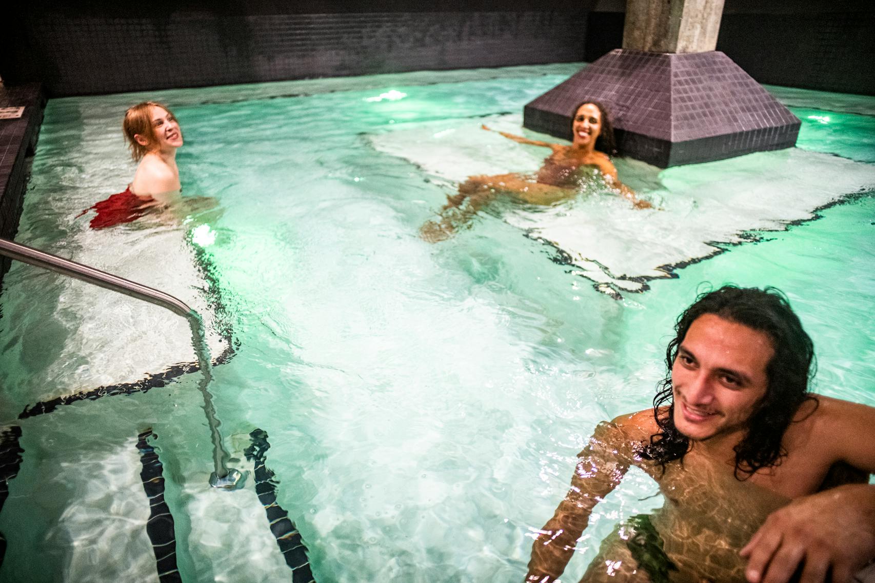 Dimitra Klein, Jaina Portwood, and Jimmy Gonzales test out the communal pool at Water Shed Spa in Minneapolis. 