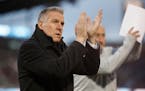 FILE - In this March 24, 2018, file photo, Sporting Kansas City's Peter Vermes acknowledges fans as he takes the pitch to lead his team against the Co