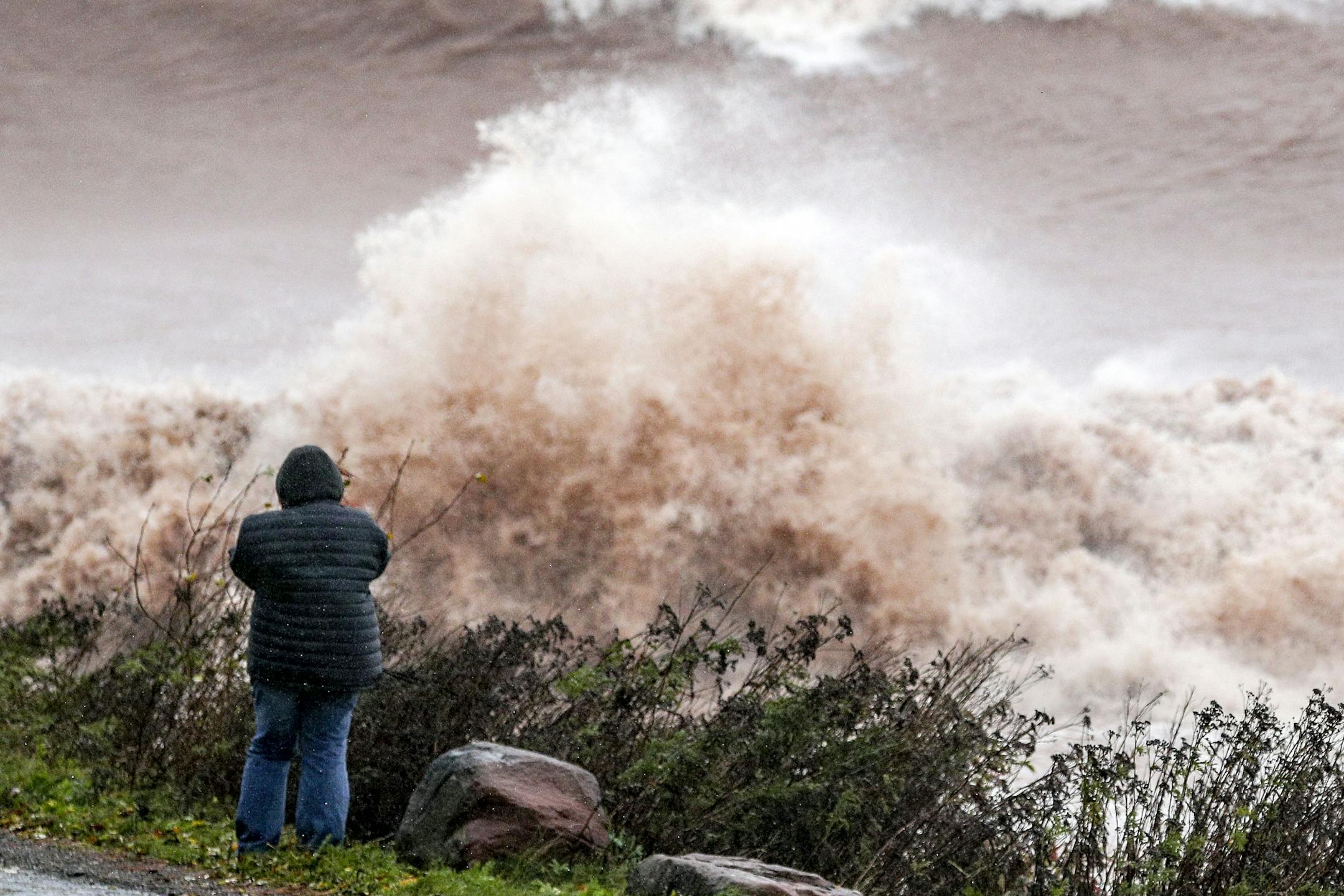A person takes photos of the large waves on Lake Superior at Brighton Beach during Wednesday's storm in Duluth. --- Clint Austin / caustin@duluthnews.com