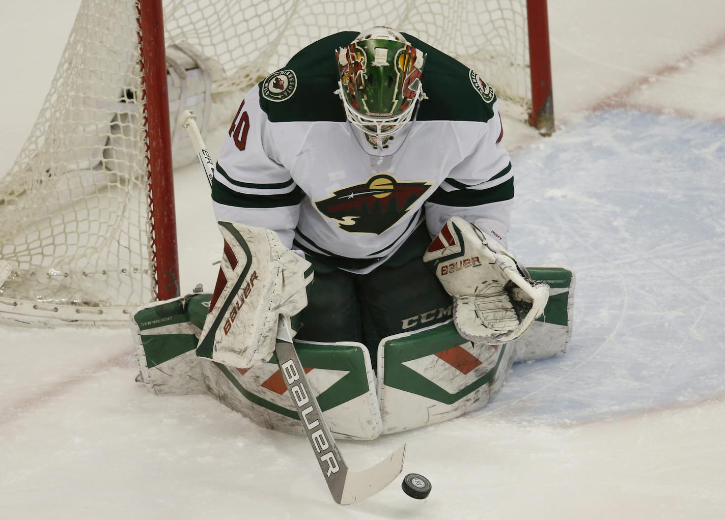 Minnesota Wild goalie Devan Dubnyk makes a save against the Colorado Avalanche in the first period of an NHL hockey game Saturday, March 26, 2016, in Denver. (AP Photo/David Zalubowski)