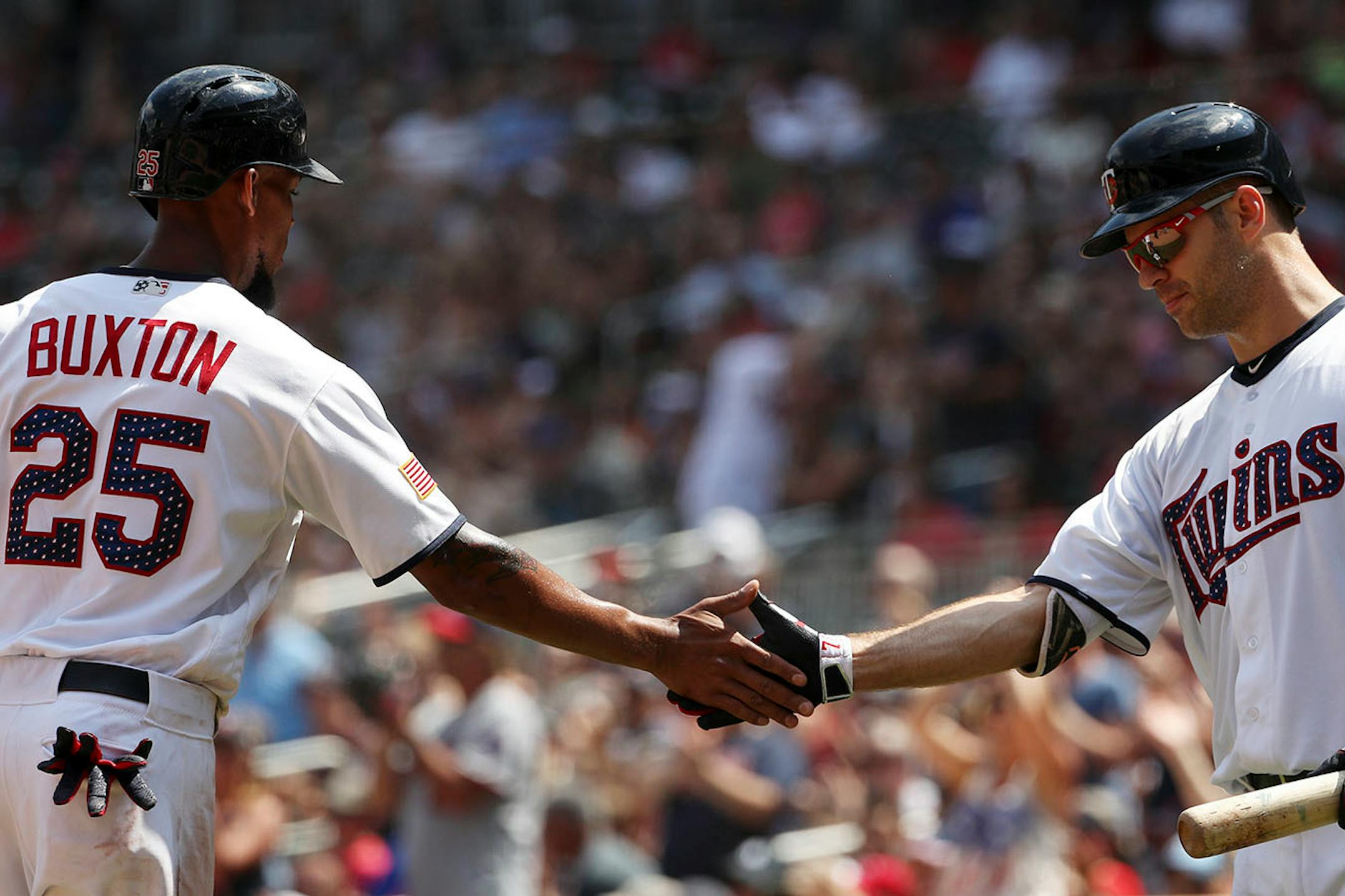 Minnesota Twins center fielder Byron Buxton (25) celebrated with Minnesota Twins first baseman Joe Mauer (7) after scoring in the fifth inning.