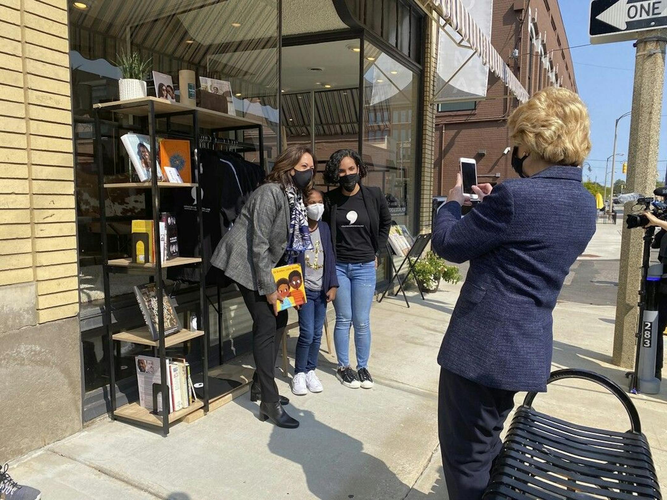 Michigan Sen. Debbie Stabenow, right, takes a picture of Vice President-elect Kamala Harris posing for a photo on Sept. 22, 2020 with Egypt Otis and her nine-year-old daughter Eva Allen in front of their downtown Flint, Mich., bookstore, the Comma Bookstore & Social Hub. For countless women and girls, Harris' achievement of reaching the second highest office in the country represents hope, validation and the shattering of a proverbial glass ceiling that has kept mostly white men perched at the t