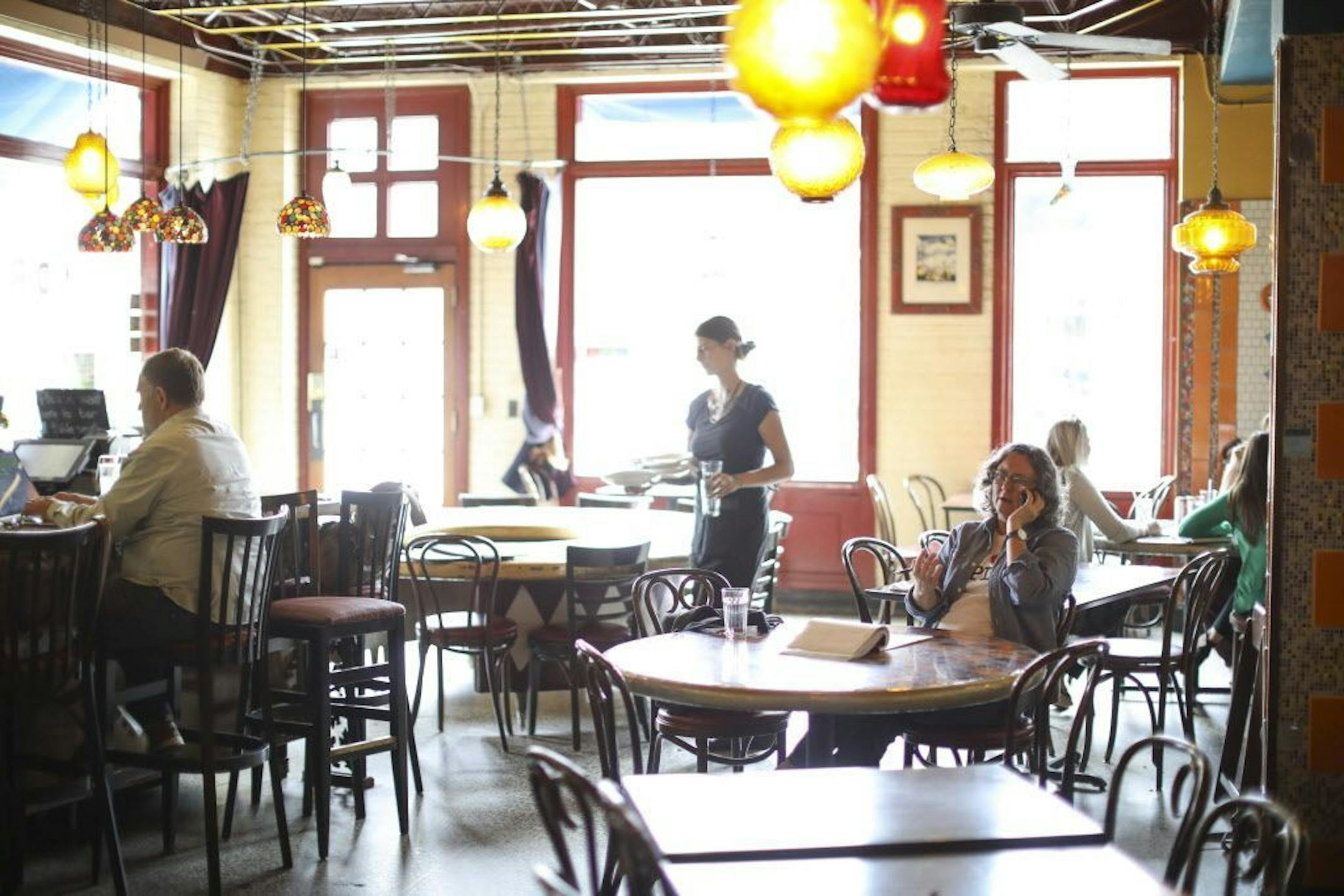 Kim Bartmann on the phone while at her regular table, 17, between meetings in Barbette.