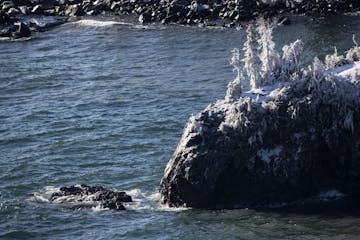 December, 2019: The collapsed Tettegouche sea stack lay in Lake Superior with small waves crashing on it. The Minnesota landmark collapsed during the 