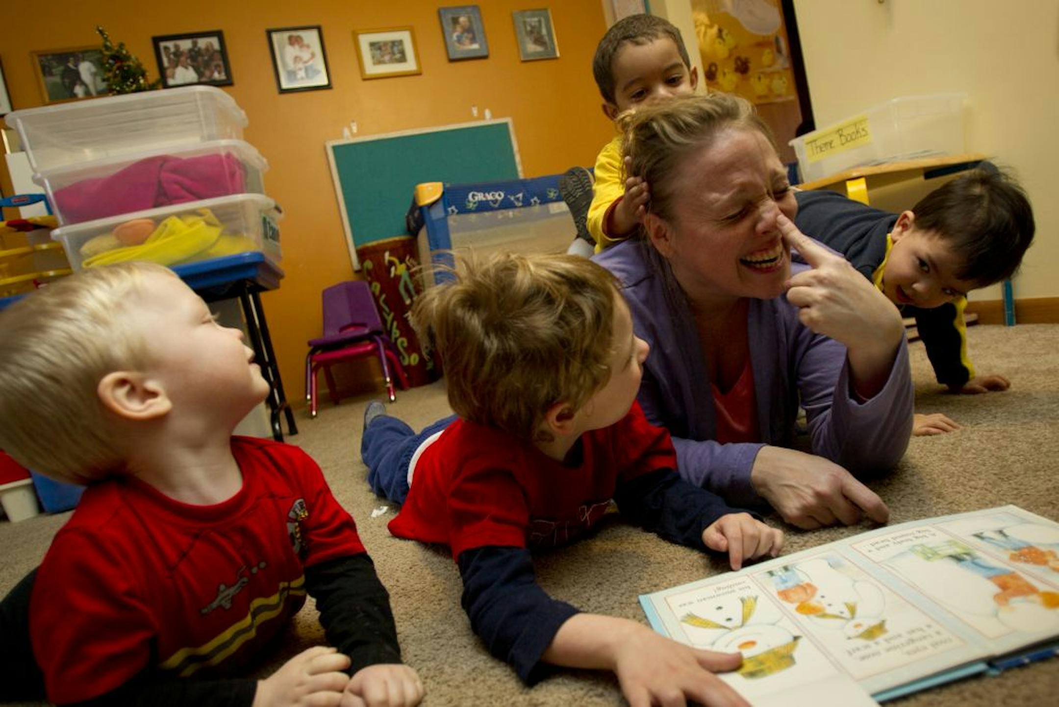 Child-care provider Lisa Thompson read from the book "The Snowman" at her home day care.