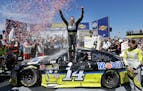Tony Stewart, center, celebrated after winning the NASCAR Sprint Cup Series auto race Sunday, June 26, 2016, in Sonoma, Calif.