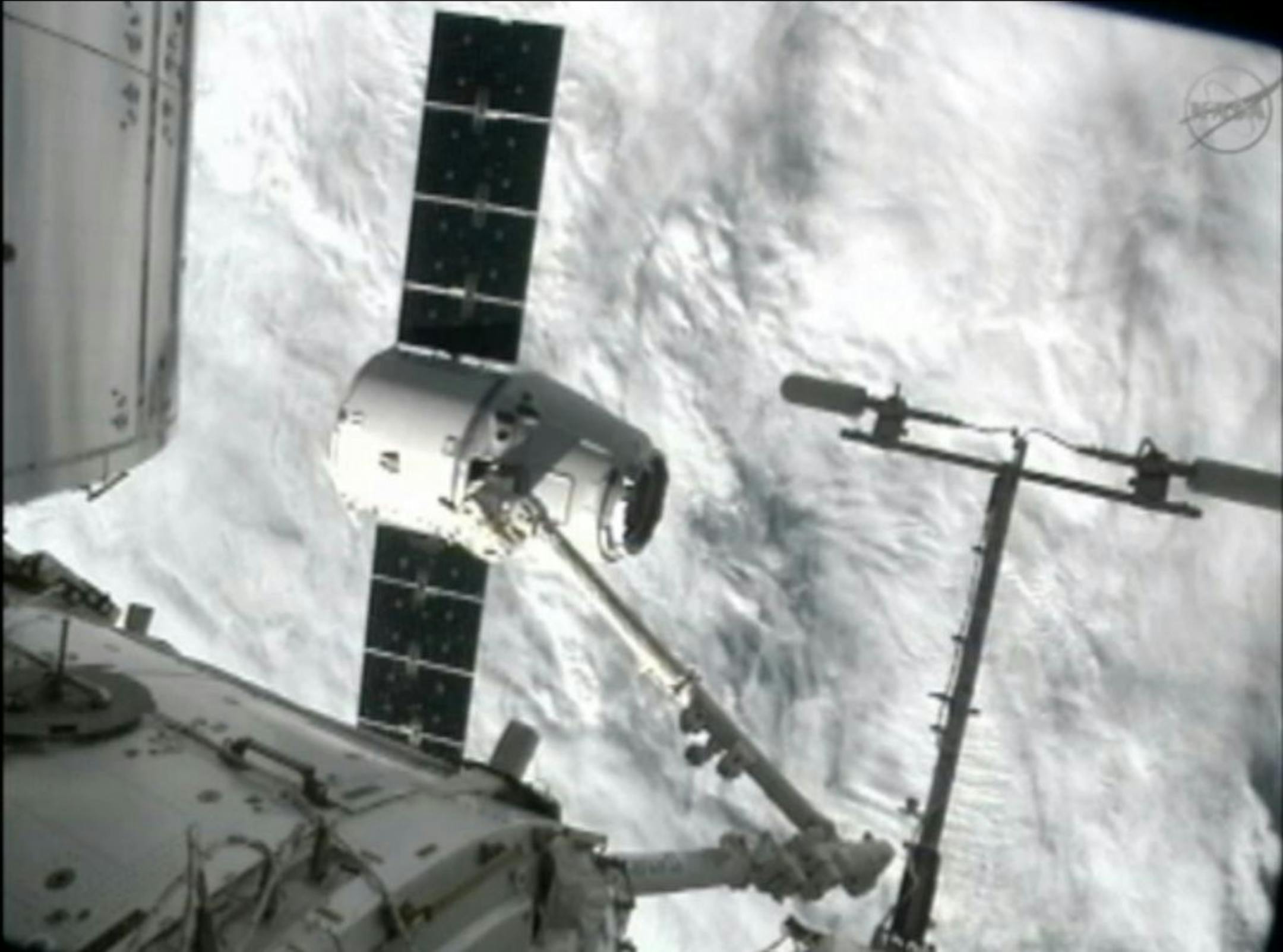 This image from NASA-TV shows the capture of the Dragon capsule by a robot arm on the International Space Station as they passed over the South Atlantic Ocean early Wednesday Oct. 10, 2012. It's the first official delivery by the California-based SpaceX company under a $1.6 billion contract with NASA. The contract calls for 12 such shipments.