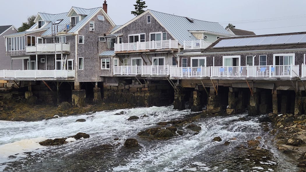 The Tidewater hotel is elevated above a channel of flowing tidal waters on Vinalhaven Island, Maine. 