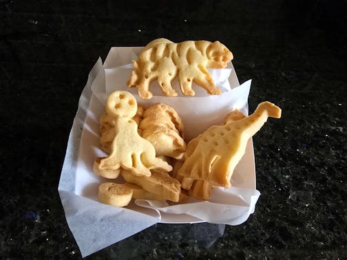 A paper basket of animal crackers on a black countertop