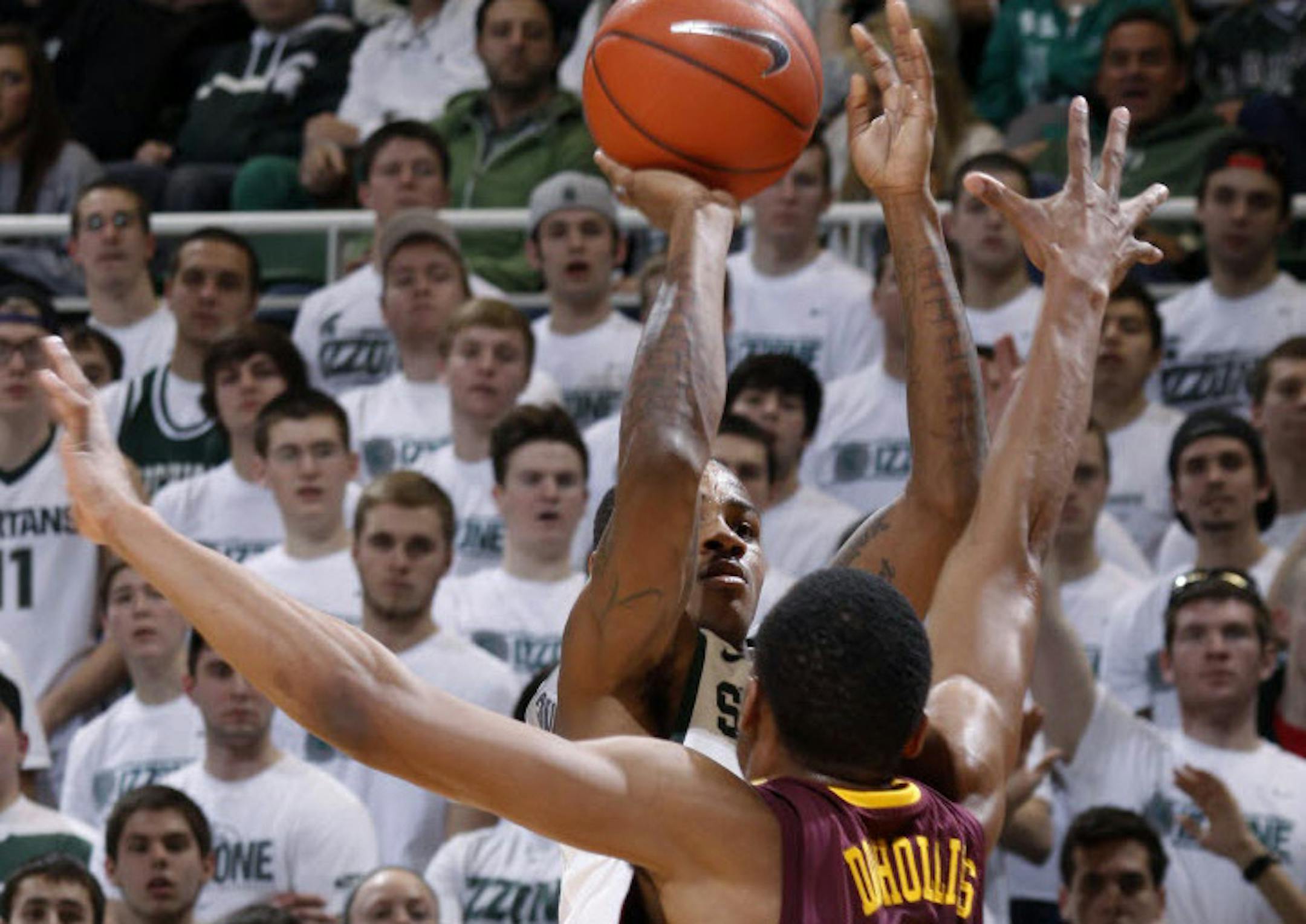 Michigan State's Keith Appling shoots a 3-pointer against Minnesota's Andre Hollins (1).