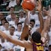 Michigan State's Keith Appling shoots a 3-pointer against Minnesota's Andre Hollins (1).