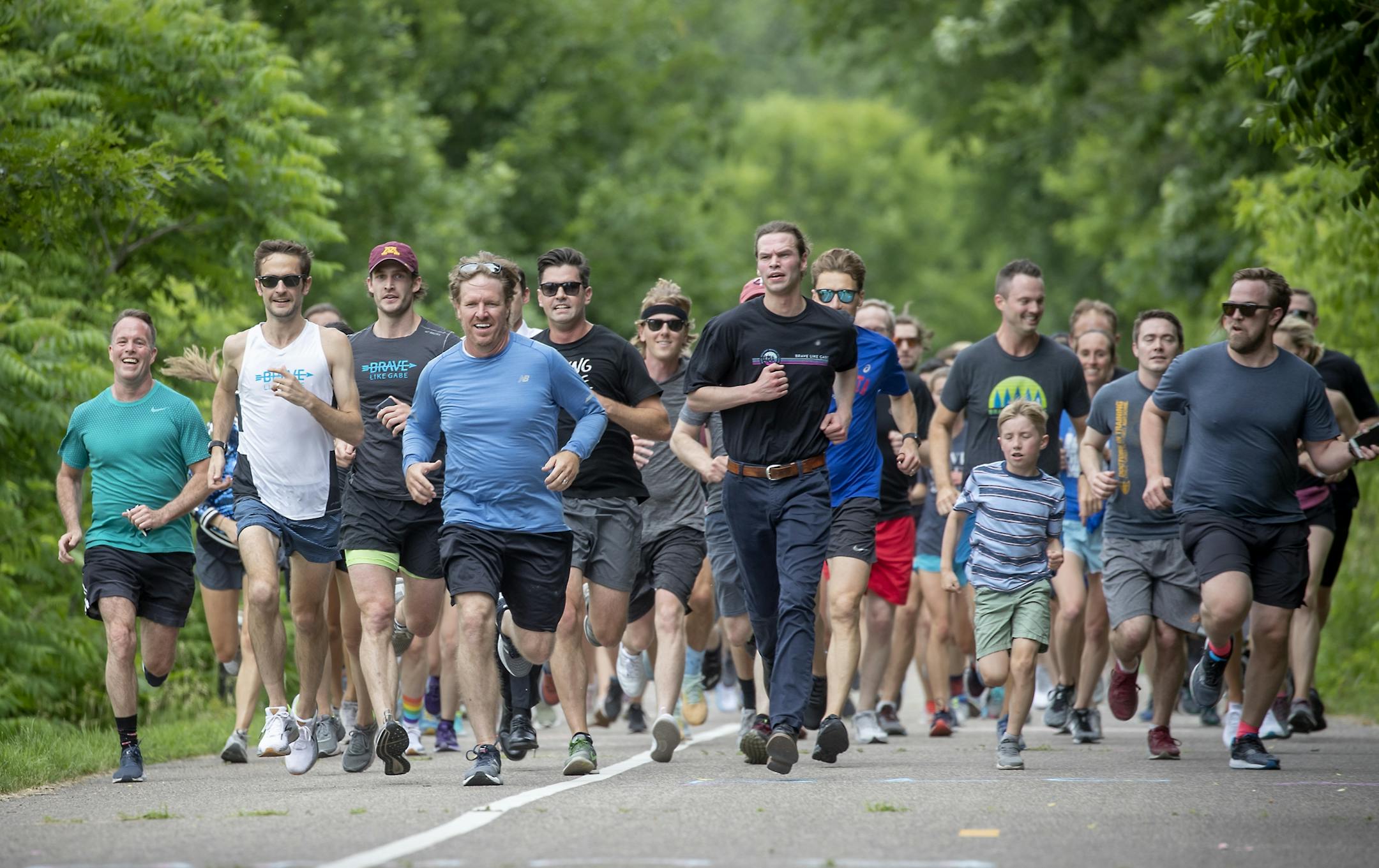 Led by Justin Grunewald, second from left, and reality celebrity Chip Gaines, in blue, family, friends and supporters finished a one-mile run in honor of Gabriele Grunewald after her burial just outside Hillside Cemetery.