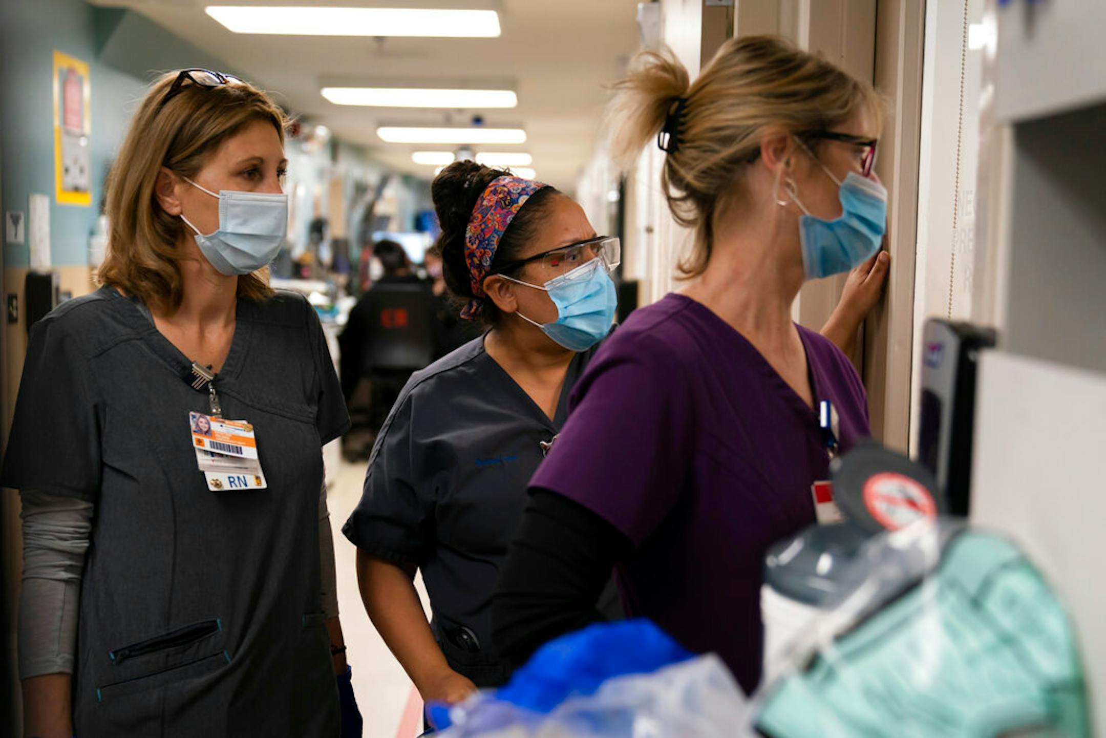 Registered nurse Kristina Shannon, chaplain Andrea Cammarota and ER charge nurse Cathy Carter watched as medical workers tried to resuscitate a patient who tested positive for coronavirus in the emergency room at Providence Holy Cross Medical Center in the Mission Hills section of Los Angeles on Nov. 19.