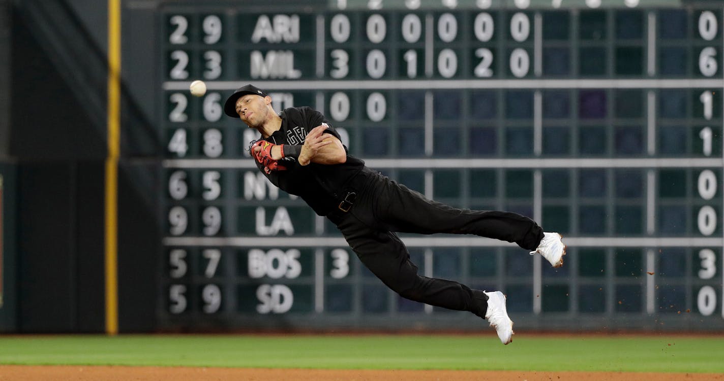 Los Angeles Angels shortstop Andrelton Simmons throws to first base for the out after fielding a ground ball by Houston Astros' George Springer during the seventh inning of a baseball game Friday, Aug. 23, 2019, in Houston. (AP Photo/David J. Phillip) ORG XMIT: TXDP115