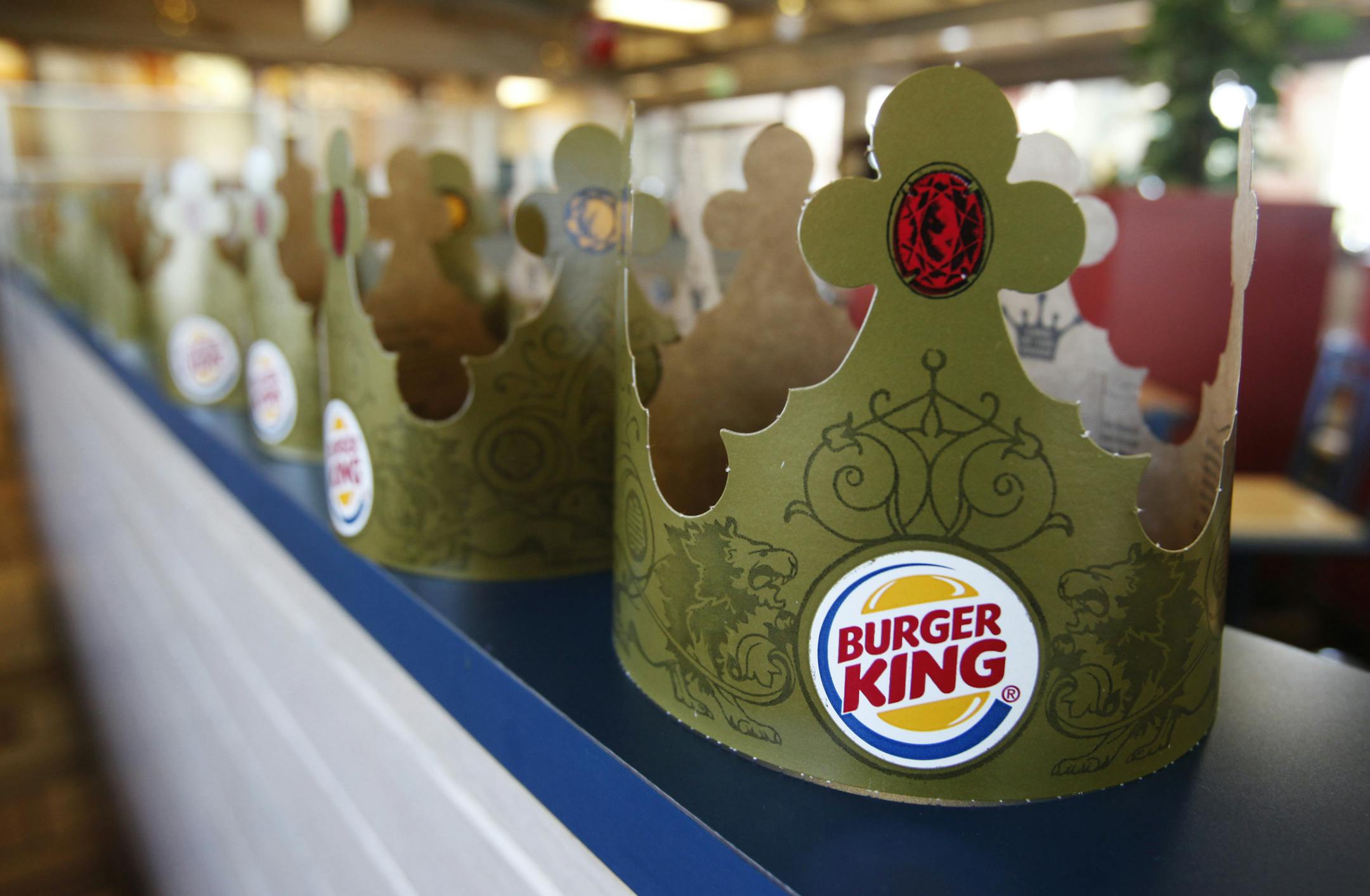 FILE - In this Aug. 23, 2010, file photo, Burger King crowns are on display in a Mountain View, Calif. store. Burger King said Monday, Oct. 28, 2013, that it saw sales trends in North America turn positive after last month's launch of "Satisfries," which have 20 percent fewer calories than its regular fries because of a batter that absorbs less oil. (AP Photo/Paul Sakuma, File)