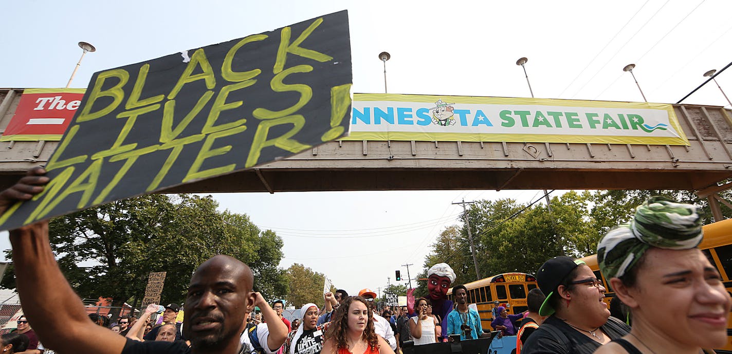 People march during a Black Lives Matter protest near the front gate of the Minnesota State Fair, Saturday, Aug. 29, 2015, in Falcon Heights, Minn. (Jim Gehrz/Star Tribune via AP) MANDATORY CREDIT; ST. PAUL PIONEER PRESS OUT; MAGS OUT; TWIN CITIES LOCAL TELEVISION OUT ORG XMIT: MIN2015083111420315