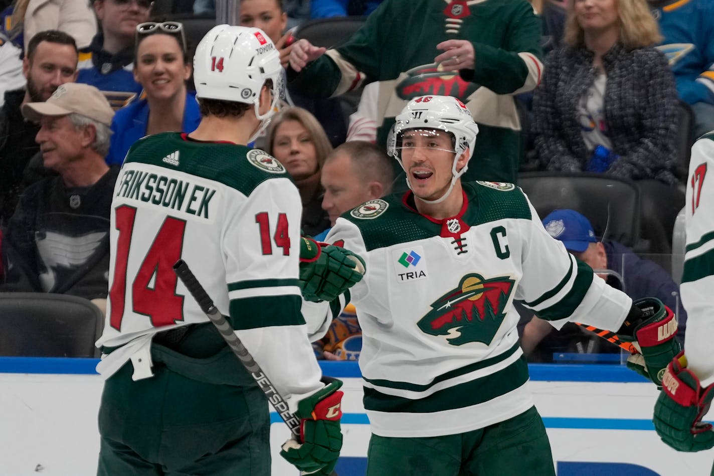 Minnesota Wild's Jared Spurgeon is congratulated by Joel Eriksson Ek (14) after scoring during the third period of an NHL hockey game against the St. Louis Blues Saturday, Dec. 31, 2022, in St. Louis. (AP Photo/Jeff Roberson)