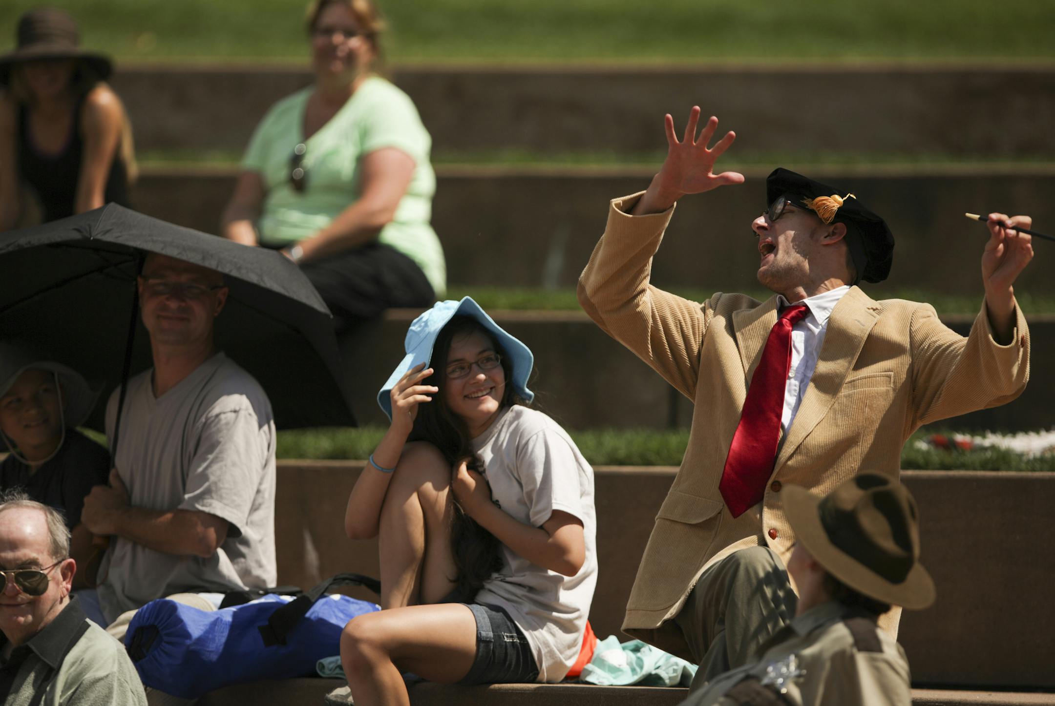 Amanda Baumgart, in the blue hat, reacted as Neal Beckman's schoolmaster character Holofernes visited the audience during a Sunday performance of Shakespeare's "Love's Labors Lost" at Centennial Lakes Park in Edina. Amanda attended the show with her dad, Ruediger, and brother, Gustav, left.